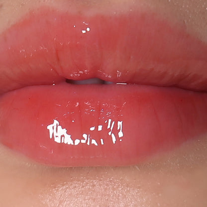 sheer red lip gloss swatched on lips